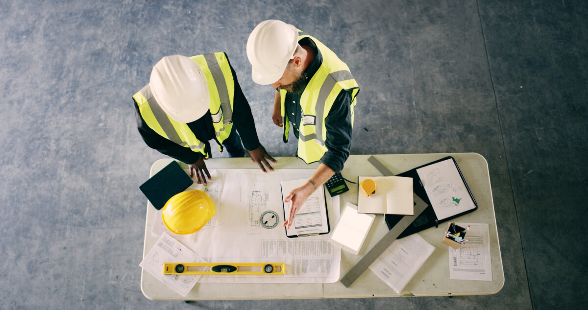 Blueprint, meeting and architecture with people and documents for discussion, engineering and contractor. Construction team, floor plan and top view of employee and paperwork for renovation space.