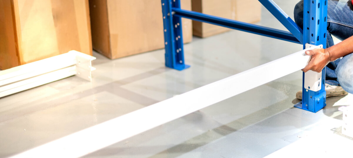 Male hand preparing to assembling the metal rack in a warehouse or storage and shelves for cardboard boxes of products